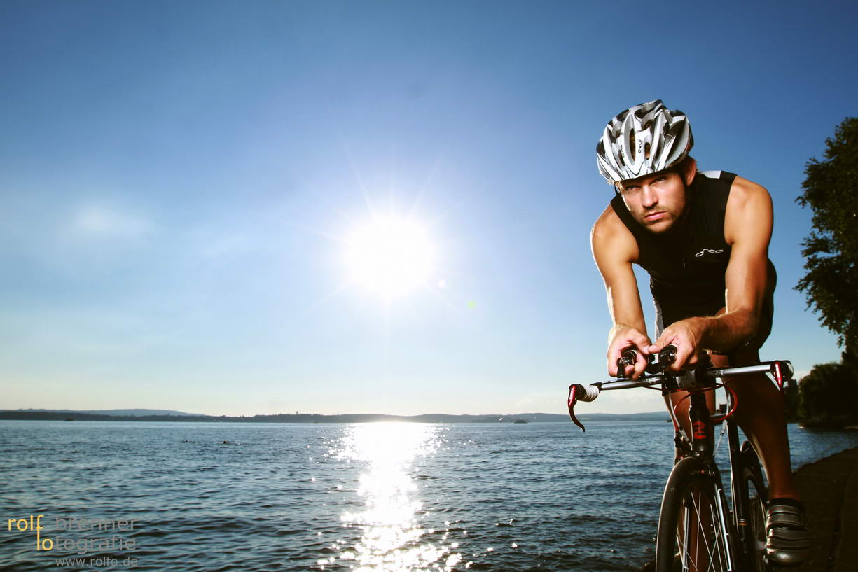Triathlet mit seinem Fahrrad am Bodensee