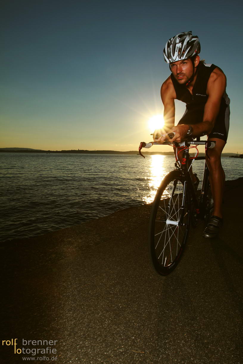 Triathlet mit seinem Fahrrad am Bodensee